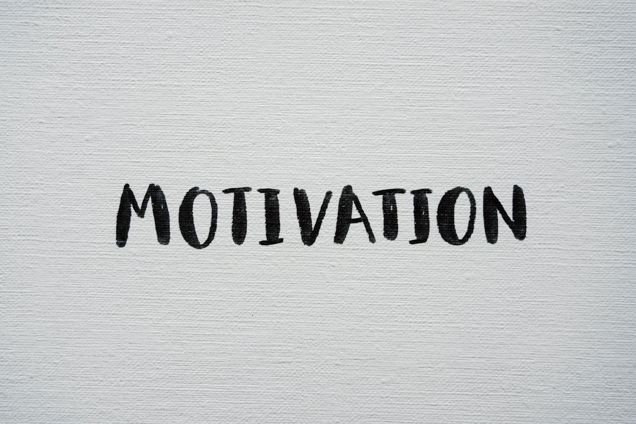 Inspirational word 'Motivation' in black on a white textured canvas background.